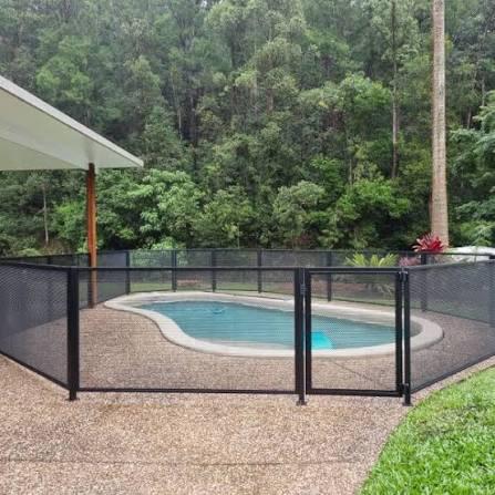Outdoor swimming pool enclosed by metal safety fencing
